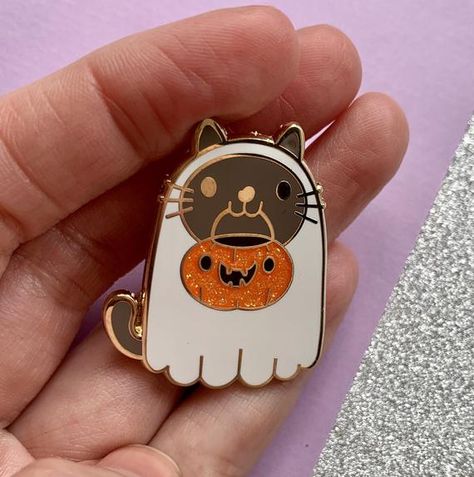 Cute and spooky enamel pin featuring a ghost cat ready to go trick or treating.Features glitter and gold plated detailing.Approx 35mm at the widest point with a rubber clutch.**This listing is for one pin only, the group photo is to show the whole range of Halloween pins** Cat With Pumpkin, Cute And Spooky, Halloween Coffin, Cat Enamel Pin, Shirt Pins, Halloween Pins, Ghost Cat, Enamel Pin Badge, Cool Pins