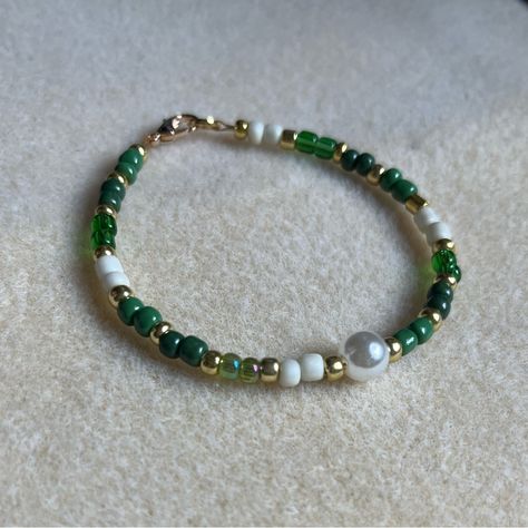 - One Of A Kind Beaded Bracelet - Featuring Green, White, And Gold Seed Beads With A White Pearl Bead At The Center - Gold Colored Hardware - Clasps Closed. No Stretch. - Size/ Circumference Is 7” - Handmade (By Myself). Perfect To Treat Yourself Or To Give As A Unique Gift! **Add 2 Jewelry Items Marked “2 For $20” To Your Bundle And I Will Send You An Offer For $20** Tags: Beaded, Handmade Jewelry, Colorblock Check Out The “Boutique” Tab In My Closet For Handmade Earrings, Bracelets, And Neckla Green And Blue Seed Bead Bracelet, Green And White Beaded Bracelet, Green Bead Bracelet Ideas, Beaded Crystal Bracelets, Green Beaded Jewelry, Green Bracelet Beads, Green Bracelet Ideas, Beaded Bracelets Patterns, Cute Beaded Bracelets