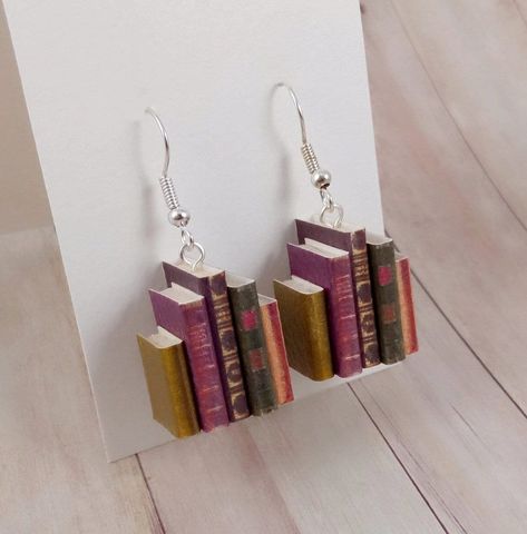 Nice that you stopped by  Our latest earring creation "Book Series Old" is a great gift idea - not just for book lovers. 📚 Each earring consists of five small closed books, which we have lovingly created by hand. The booklets show old, antique book designs. The books can still be seen through the leather-like structured surface of the books more like antique, old books. The core of the booklet is made of super light balsa wood, which is why these earrings are absolutely light and offer absolute Book Earrings Diy, Bookish Earrings, Paper Art Christmas, Mini Book Earrings, Silly Earrings, Old Earrings, Souvenir Art, Book Earrings, Fishing Hooks