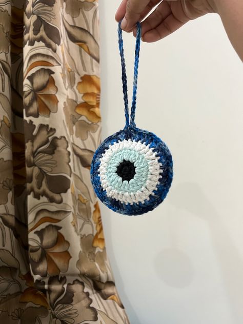 Crochet evil eye bag charm. It can also be used as a car accessory. #crochet #evileyewallhanging Crochet Evil Eye, Evil Eye Crochet, Crochet Car Charm, Crochet Evil Eye Keychain Free Pattern, Evil Eye Crochet Wall Hanging, Crochet Steering Wheel Cover Evil Eye, Crochet Evil Eye Car Hanging, Evil Eye Car Charm, Crochet Eyes