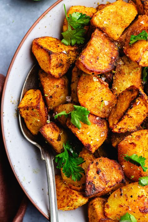 Curry roasted potatoes in a serving bowl topped with cilantro. Lamb Recipes Indian, Curry Potatoes, Indian Potato Recipes, Indian Side Dishes, Potatoes In Oven, Greek Potatoes, Potato Sides, Roast Potatoes, Curry Dishes