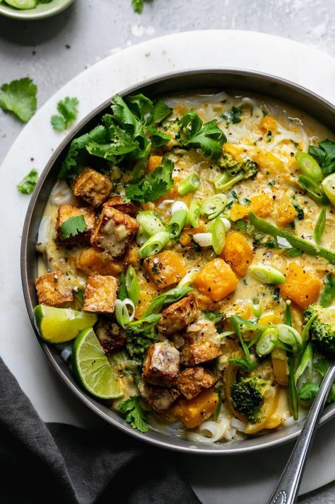 Butternut Squash Green Curry Rice Noodle Bowls are the ultimate healthy comfort food for busy weeknights. These bowls are filled with butternut squash, crisp veggies, rice noodles, and a silky smooth coconut milk green curry sauce. Lime juice, cilantro, and scallions brighten up this cozy dish and make it over-the-top delicious! #greencurry #vegetarian #vegan #plantbased #ricenoodles Green Curry Rice, Rice Noodle Bowls, Green Curry Sauce, Vegetable Noodles, Fall Comfort Food, Curry Rice, Rice Noodle, Healthy Comfort, Green Curry