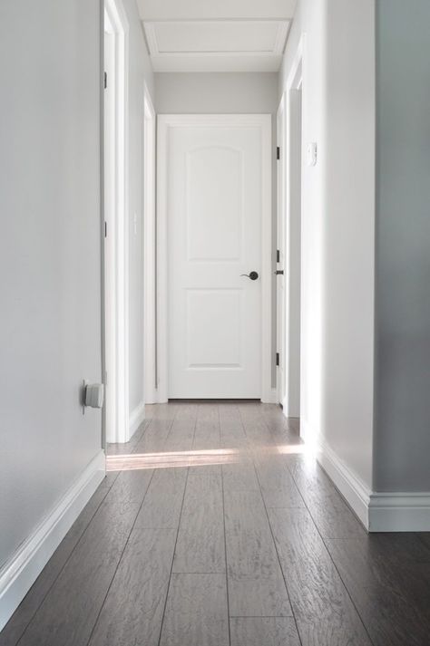 A fresh coat of paint can make all the difference. Check out this DIY home makeover from Ashley, of Little Glass Jar, to find tons of color inspiration. Ashley painted her hallway a neutral shade of Dolphin Fin to give it a tried-and-true classic style. Pair this light gray hue with bright white and dark accents to create an open and airy style. Behr Light Grey Paint Colors, Behr Gray Paint, True Grey Paint Color, Behr Paint Colors Grey, Looking Glass Paint, Dolphin Fin, Paint Makeover, Grey Hallway, Light Grey Paint Colors