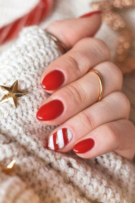 Close-up of festive winter nail idea featuring classic red polish with an accent candy cane design of white and gold stripes, perfect for the holiday season. Festive Manicure, Candy Cane Nails, Christmas Gel Nails, Nail Candy, Cute Gel Nails, Design Nails, Manicure Ideas, Festive Look, Xmas Nails