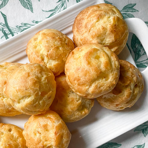 Light and airy on the inside and slightly crisp on the outside, gougères (cheese puffs) make crowd-pleasing appetizers, snacks, or accompaniments to your favorite mocktail or glass of wine. #appetizers #cheesepuffs #cheddar #parmesan #gougeres #frenchrecipes #apero #horsdoeuvres #snacks #partyfood #entertaining #holiday #baking #savorybaking #pateachoux #pastry How To Make Pate, Gougeres Recipe, Wine Appetizers, Cream Puff Recipe, Swirl Brownies, Lemon Curd Filling, Crowd Pleasing Appetizers, Puff Recipe, Cheese Puffs