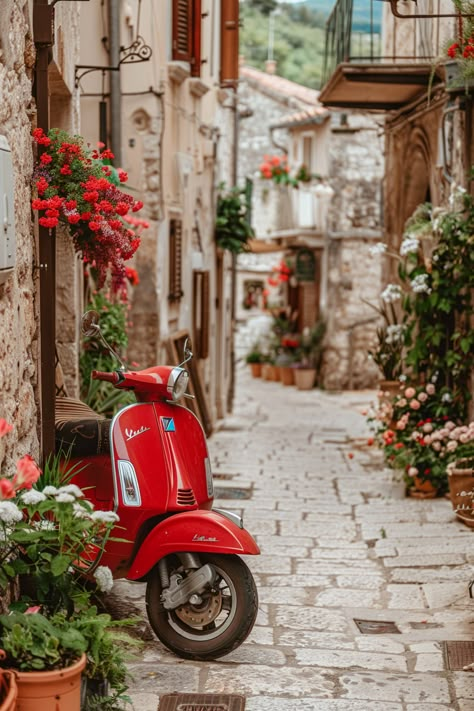 Red Vespa scooter parked in cobblestone alley adorned with vibrant flowers in quaint European village. Vintage Italian Photos, Italy Dolce Vita, Italian Pictures Art, Italian Pictures, Italy Mood Board, Italy Villages, Italy Wallpaper, Red Vespa, Italian Scooter