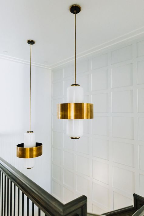 Modern lighting fixture in gold above a stairway with paneled accent wall. | shorelineconstructionsc.com Paneled Accent Wall, Cottage Style Beach House, Entryway Lights, Globe Lighting, Pendant Lights Kitchen, Lights Kitchen, Entryway Lighting, Building A Home, Beach House Style