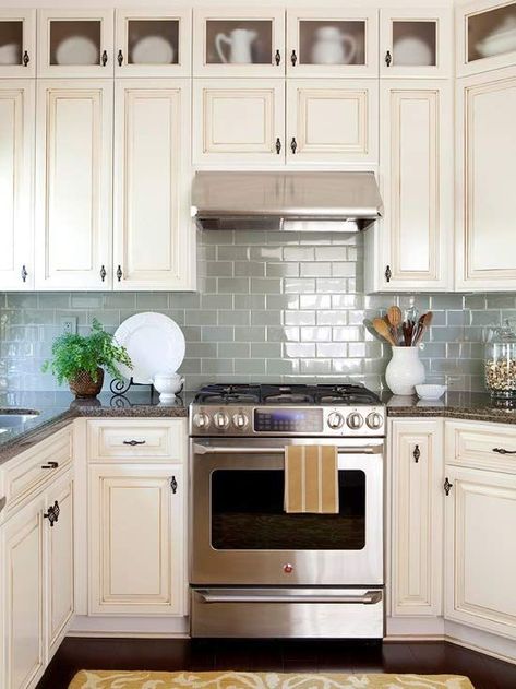 Do you have a small kitchen space? Try adding glass shimmering tiles to open the space up. Colorful Kitchen Backsplash, Cream Colored Kitchen Cabinets, White Kitchen Backsplash, Subway Tile Kitchen, Herringbone Backsplash, Diy Backsplash, Kitchen Backsplash Designs, Farmhouse Kitchen Cabinets, Kitchen Cabinets Decor