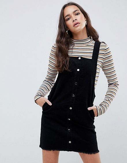 Pimkie popper Corduroy Dungaree Dress in black Black Corduroy Dress Outfit, How To Style Dungaree Dress, Jumpskirt Outfit, Dungarees Outfit Dresses, Black Pinafore Dress Outfit, Dungree Styles Dress, Black Overall Dress Outfit, Dungaree Dress Outfit, Black Dungaree Dress