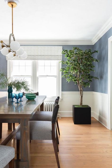 HGTV loves this blue contemporary dining room with white wainscoting and crown moding, dark wood furniture and light hardwood floor. Gray Accent Wall Dining Room, Blue Gray Dining Room Walls, Dining Room Design Wainscoting, Blue Wainscoting Dining Room, Dining Room With White Wainscoting, Dining Room Blue Walls, Light Blue Dining Room Walls, Two Toned Dining Room Walls, Blue Wall Dining Room