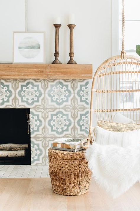 A tan and blue Moroccan style tiled fireplace boasts a rustic wood mantel and is positioned behind a Serena & Lily Hanging Rattan Chair paired with a woven ottoman. Hanging Rattan Chair, Hanging Rattan, Wood Mantels, Ideas Hogar, Fireplace Ideas, Bathroom Trends, Style Deco, Cabin Life, Fireplace Tile