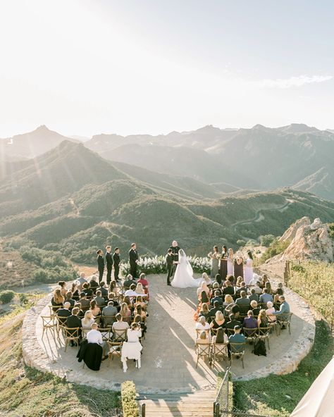 The couple's Christian ceremony, which included a ring exchange, was officiated by one of their best friend's father. It took place on the estate's helipad, which overlooked the region's sweeping hillsides. As if that backdrop weren't enough, Poppy Design Co. crafted a floral crescent to frame the bride and groom. #weddingceremony #uniqueweddingvenue #outdoorweddingideas #stunningwedding | Martha Stewart Weddings - Guests Were Blown Away by the Ceremony Space at This Formal California Wedding On Top Of A Mountain, Wedding Ceremony Ideas, Top Of A Mountain, Malibu Wedding, Unique Wedding Venues, Ceremony Arch, Christian Wedding, Martha Stewart Weddings, Outdoor Wedding Ceremony