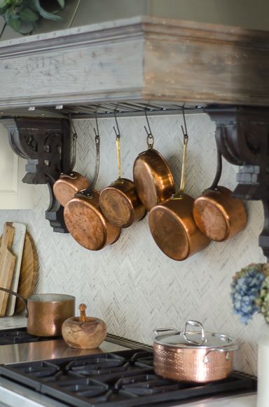 Hanging copper pots behind range. Hanging Copper Pots, Copper Pots Display, Copper Kitchen Accents, Copper Pots And Pans, Sanctuary Home Decor, Copper Kitchen Accessories, Sanctuary Home, Copper Kitchen Decor, Copper Decor