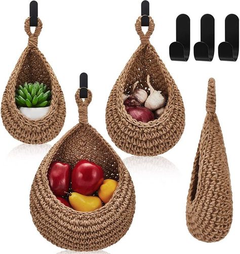 Embrace the natural charm of jute! These genuine jute hanging baskets, with cute teardrop shapes, are hand-woven, strong, and eco-friendly. They may have a slight odor, but it fades over time. Perfect for kitchen organization or as flower holders, these bohemian-style baskets add rustic beauty to your decor. Let your fruits and veggies breathe in these breathable, multi-hole baskets. Choose practicality and embrace the earthy vibes of jute! Hanging Baskets Over Dining Table, Wall Baskets Outside, Potato Basket Kitchen, Basket Attached To Wall, Wall Storage With Baskets, Hang Storage Baskets On Wall, My Kitchen Pins, Fruit Basket Hanger, Hook Basket Storage