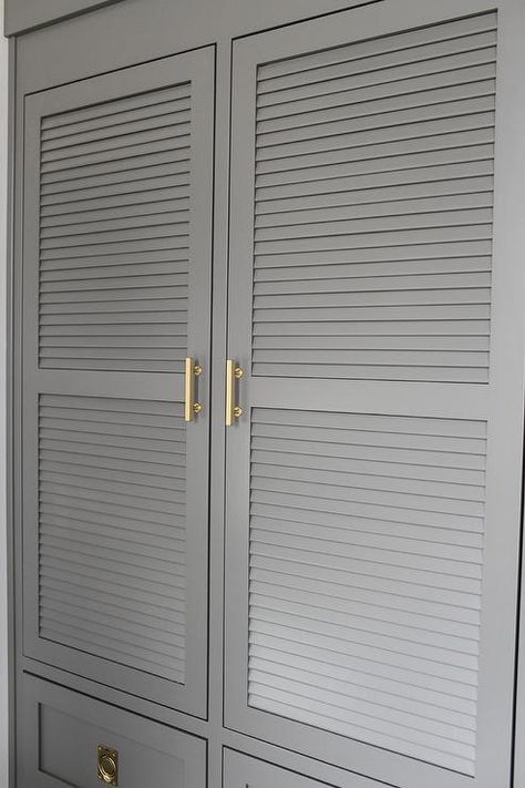 Charcoal gray laundry room features charcoal gray louvered cabinets adorned with brass handles built above stacked gray drawers adorned with vintage brass ring hardware. Mediterranean Laundry, Louvered Door Ideas, Gray Beadboard, Beadboard Cabinets, Contemporary Laundry, Cottage Laundry, Contemporary Laundry Room, Landry Room, Herringbone Tiles