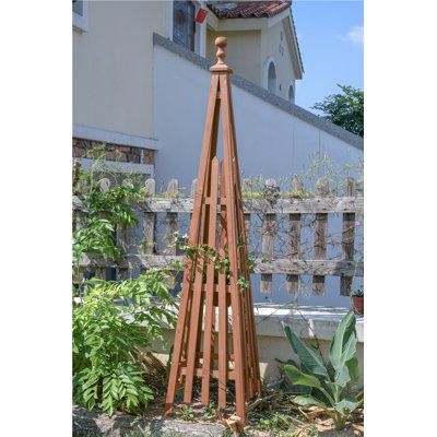 Caydenn wood obelisk trellis matches the traditional "ball finial" style of pyramid trellis that you've grown accustomed to. The four lattice side panels are shipped individually, and with the included hardware, they assemble into a firm support for your garden climbers. Perfect for small cherry tomatoes, sweet snow peas, or just a nice decoration in the backyard. | Wade Logan® Caydenn Wood Obelisk Trellis Wood / Cedar in Brown | 67.5 H x 14.5 W x 14.5 D in | Wayfair Climbing Flowers Trellis, Pyramid Trellis, Wood Obelisk, Garden Climbers, Wooden Obelisk, Obelisk Trellis, Flower Trellis, Wood Trellis, Climbing Flowers