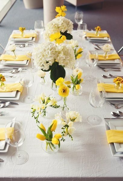 Yellow tulips, ranunculus, freesia, and white hydrangea in large bases and bud vases atop a crinkle ivory linen and yellow napkins Lemon Themed Bridal Shower, Yellow Wedding Theme, Yellow Napkins, Tulip Wedding, Yellow Party, White Hydrangeas, Flowers Arrangements, Yellow Tulips, Easter Centerpieces