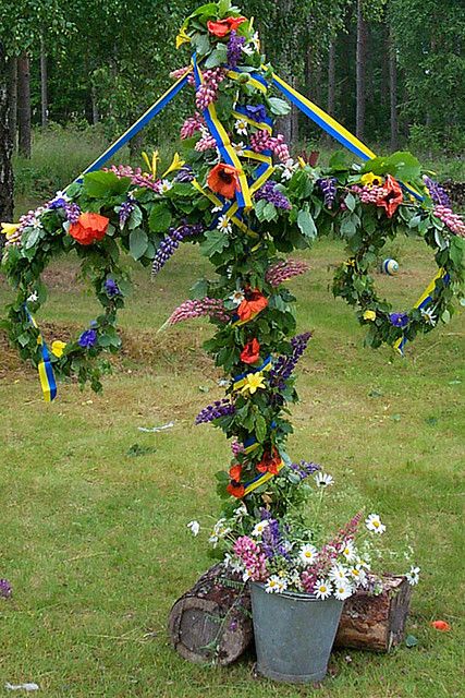 Midsummer - Midsummer / AND May Day (May 1st) the ribbons represent the flag -- this one is Swedish -- the 2 wreaths hang on the T shape pole -- w/vines flowers wrapped around it all -- There's a ribbon winding around to music with Folk in National Costumes from their regions. Swedish Traditions, Swedish Girls, Scandinavian Countries, Swedish Style, May Days, Nordic Countries, How To Wrap Flowers, Hanging Wreath, Beltane