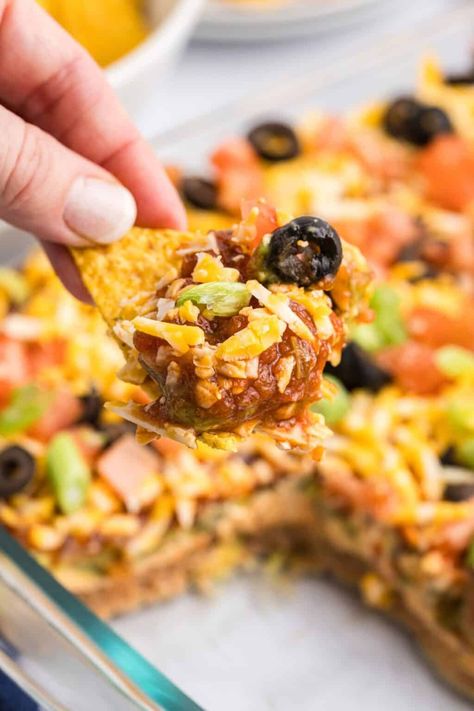 Perfect for parties and potlucks, this Mexican 7 Layer Dip is easy and fun make! This dip features layers of all your favorite taco ingredients including refined beans, guacamole, and salsa. Seven layer dip is an epic entree or appetizer that everyone will keep coming back for! Layered Dips For Parties, 7 Layer Dip Mexican, Mexican 7 Layer Dip, Seven Layer Bean Dip, 7 Layer Mexican Dip, Bean Dips, Layer Taco Dip, 7 Layer Bean Dip, 7 Layer Taco Dip