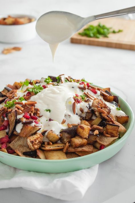 This Middle Eastern Eggplant Fatteh is full of flavor and completely vegetarian. A crunchy pita bread layer, topped with roasted eggplant and a delicious yogurt tahini sauce. And don't forget all the garnish!! Eggplant Fatteh, Yogurt Tahini Sauce, Middle Eastern Eggplant, Hungry Paprikas, Warm Appetizers, Easy Eggplant, Paprika Recipes, Healthy Vegetable Recipes, Middle Eastern Dishes