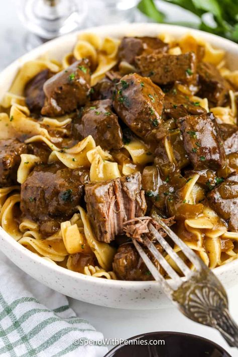 This delicious beef and noodles recipe is as tasty as stroganoff, but so much easier. Chunks of stew beef are tossed in garlic-seasoned flour, then browned on the stovetop and slow-cooked with aromatic vegetables and herbs until fork tender. Bring it back to the stovetop to make a rich gravy, then serve over egg noodles with a side of broccoli. Leftovers go great in soup or stir fried dishes. #beefandnoodlerecipe #beefandnoodles #recipe #spendwithpennies Beef Tips And Noodles, Egg Noodle Recipes, Leftover Beef, Spend With Pennies, Stir Fry Dishes, Beef Casserole Recipes, Beef Tips, Crockpot Beef, Beef And Noodles