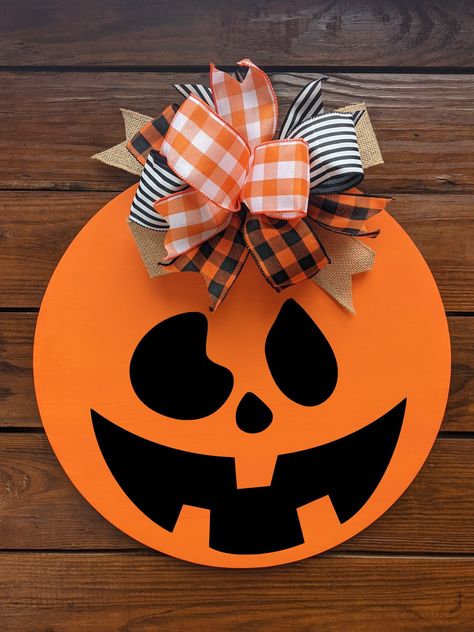 Halloween Door hanger YOU HAVE TO CHOOSE WHICH FACE YOU WANT ON DOOR HANGER, IF NONE IS CHOOSEN THEN FACE 5WILL BE USED!! MAKE SURE PICK WHAT YOU WANT  What a great way to add some fun to your front door. Lovely colors with bow. This piece comes ready to hang , can also be used indoors. A great piece for any time. These signs make a great statement to any home decor. They are made of 12 OR 18 inch round. Comes with felt on back so it doesn't hurt the doors. they are are not heavy and look great October Door Hanger, Door Hanger Halloween, Halloween Decor Front Door, Diy Halloween Door Hanger, Halloween Door Signs, Wooden Halloween Signs, Pumpkin Fall Wreath, Pumpkin Halloween Decor, Door Hanger Bow