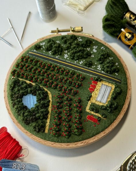 I’ve added the final touches to this apple orchard! There are a lot of elements in this piece that remind me of the acreage I grew up on. The barn, the dirt paths around the yard, the dugout surrounded by trees, the highway, and the large fields beside our place. My family always said I was a city girl stuck in a small town. But now that I’m constantly surrounded by hustle and bustle, and cars and large buildings, I often miss nature fully surrounding me. I love the city and the opportunity ... Farm Orchard, Textile Artwork, Aerial Landscape, French Knot Stitch, Apple Farm, Textiles Artwork, Hand Embroidery Projects, Apple Orchard, Sewing Embroidery