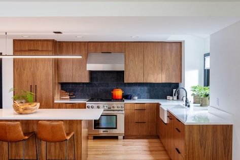 The kitchen in this whole home remodel project was gutted and received all new appliances and finishes – including walnut cabinetry, white quartz countertops, and porcelain backsplash tile. See more of this project and others on our website! Warm Kitchen, Mid Century Modern Kitchen, Black Walnut Wood, Remodel Kitchen, Kitchen Inspiration Design, Updated Kitchen, Kitchen Makeover, Black Walnut, Interior Design Studio