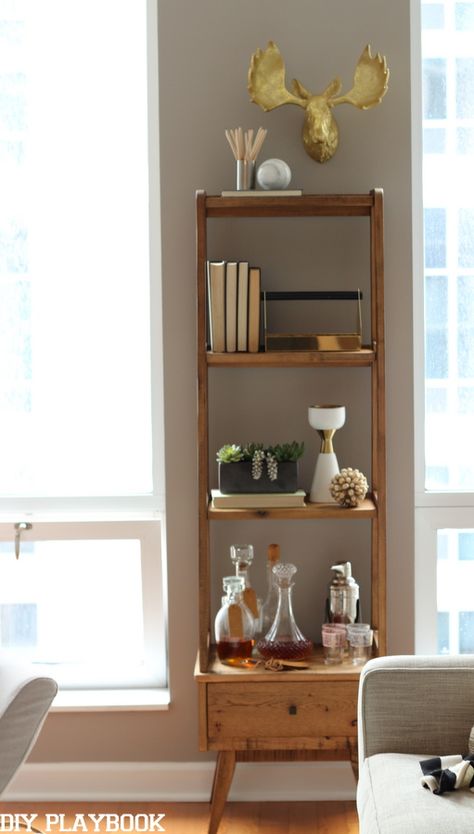 Add a slim shelf to your family room to hold books, bar essentials, and other home decor. Love this idea for a living room space. Tall Shelf Decor Living Room, Shelves Modern Design, Slim Bookshelf, Bookshelf Bar, Condo Makeover, Slim Shelf, Narrow Shelf, Diy Esstisch, Bookshelf Makeover