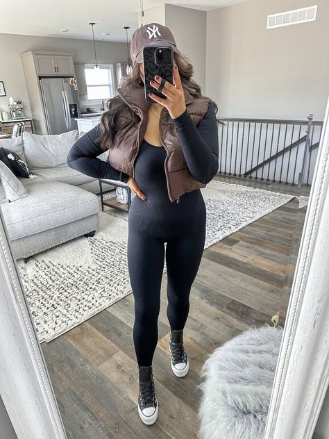 Leather Platform Converse Outfit, Brown Baseball Hat Outfit, Black Athletic Jumpsuit Outfit, Jumpsuit And Puffer Jacket Outfit, Black Active Jumpsuit Outfit, Black Jumpsuit With Puffer Vest, Black Jumpsuit Outfit Casual Sneakers, Jumper Outfit Ideas Jumpsuits, Black Onesie Outfit Women