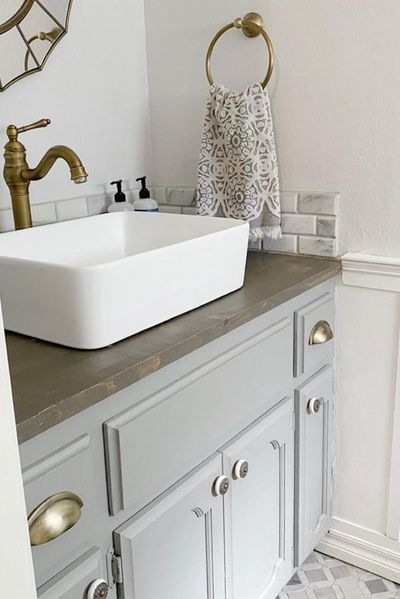 From 1970s wallpaper to updated farmhouse style guest bath, this before and after bathroom makeover complete with antique brass fixtures is a must-see! #guestbathroomideas #bathroomrenovation #bathroomremodel #bathroomdesignideas Half Bath Makeover, 1970s Wallpaper, Updated Farmhouse, Buffet Makeover, Rustic Bathroom Shelves, Guest Bathroom Remodel, Bath Makeover, Log Cabin Designs, White Bathroom Tiles