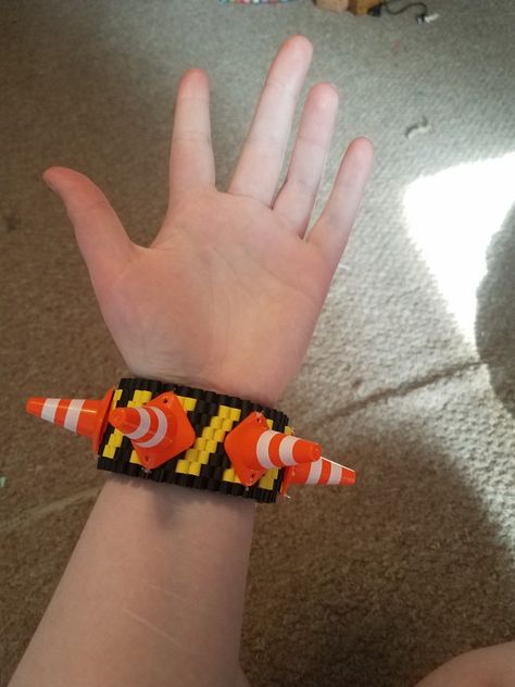 caution tape and traffic cone rotating kandi cuff made with perler beads and toy traffic cones Tape B Perler, Kandi Kid Outfit, Kandi Cuff Ideas, Rotating Kandi Cuff, Pony Bead Projects, Kandi Inspo, Kandi Cuffs, Caution Tape, Diy Kandi