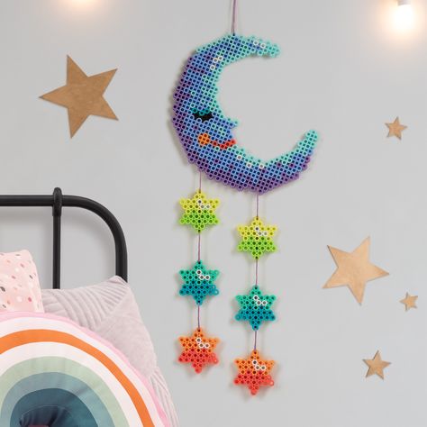 Add this whimsical wall hanging to a child’s room for a fresh pop of color. It’s easy to connect the fuse bead components using embroidery thread. Perler Bead Garland, Turkey Place Cards, Whimsical Moon, Star Wall Hanging, Hamma Beads, Beads Ideas, Bead Frame, Butterfly House, Melty Beads