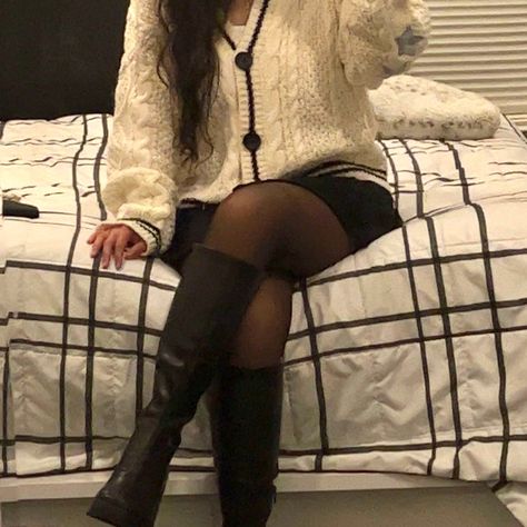 shows a girl posing on a bed with legs crossed in a autumn outfit. outfit is a folklore cardigan with a black skirt, tights, and knee-high black boots. Style Taylor Swift Cardigan, Cardigan Taylor Swift Aesthetic, Folklore Cardigan Outfit, Taylor Swift Cardigan Outfit, Folklore Cardigan, Taylor Cardigan, Outfit Cardigan, Fashion Student, Cardigan Outfit