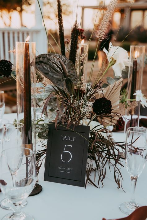 I love how candles add a touch of romance to the tablescapes. #darkwedding #gothicdetails #darkweddings #darkweddingplanner #moodyweddingplanner #gothicweddings #gothiceventplanner #gothicevents #darkevents #moodyflorals #darkromanticwedding #moodywedding #gothicwedding #alternativewedding #weddingplanner #ocweddingplanner #ocwedding #wedding #beachweddings #orangecountyweddingplanner #californiaweddingplanner #weddingcoordinator #jewelofortega #preferredvendor Dark Romantic Wedding Theme, Gothic Wedding Centerpieces, Moody Wedding Centerpieces, Black Lantern Centerpiece, Candlelit Centerpieces, Moody Tablescape, Monochromatic Wedding, Travis Wedding, Dark Romantic Wedding