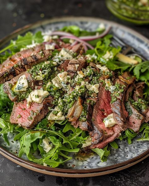 STEAK AND BLUE CHEESE SALAD WITH WALNUT PESTO DRESSING 🥗🥩 Ingredients: For the Salad: 2 rib-eye or strip steaks Salt and black pepper to taste 2 tbsp olive oil 6 cups mixed salad greens (arugula, spinach, romaine) 1 cup cherry tomatoes, halved 1/2 red onion, thinly sliced 1/2 cup blue cheese, crumbled 1 avocado, sliced 1/4 cup walnuts, toasted For the Walnut Pesto Dressing: 1 cup fresh basil leaves 1/2 cup walnuts, toasted 1/2 cup grated Parmesan cheese 2 cloves ... Steak Arugula Salad, Steak And Blue Cheese Salad, Steak And Blue Cheese, Strip Steaks, Mixed Salad, Pesto Dressing, Blue Cheese Salad, Walnut Pesto, Salad Greens