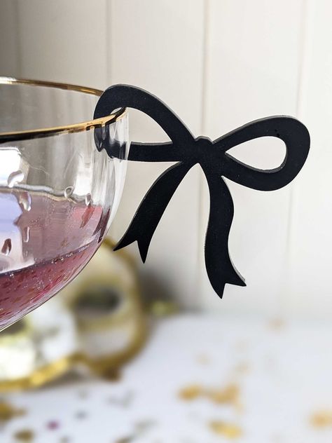 🥂  These stemless, clip-on drink bow tags are the talk of the party! Everyone is having the night of their lives, there's social media proof everywhere and these bow drink clips will create unforgettable memories that will linger long after the party ends. 🥂  🥂 Effortless setup - clip on easily and quickly to any glass 🥂 Reusable and Washable: Simply wipe clean for reuse 🥂 Glamorous Style: Perfect for any event-  hen's parties, bachelorette's, bridal showers, weddings, engagements, baby showers, tea parties, birthdays, happy hours, everyday drinking 🥂 Instant Transformation, turning any gathering into a social media-worthy affair. Leaving a lasting impression on guests and also serves as party or wedding favour! 🥂 Every coquette bow drink tag clip is 45mm x 50mm with a 2mm gap for t Drink Topper, Fest Temaer, Bridal Shower Balloons, Drink Tags, Birthday Goals, Lingerie Shower, Dinner Themes, Wedding Drink, Wedding Bows