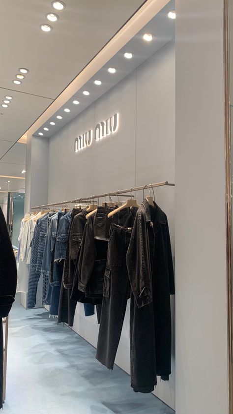 clothing rack with denim clothes in miu miu store Miu Miu Store Aesthetic, Luxury Store Aesthetic, Clothing Store Aesthetic Interior, Boutique Aesthetic Ideas, Dior Store Aesthetic, Fashion Store Design Boutiques, Aesthetic Clothing Store Interior, Harrods Aesthetic, Flagship Store Design