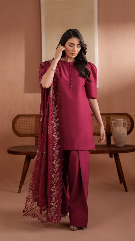 Adelia  - A delicate blend of traditional and contemporary, this short shirt in Burgundy boasts a buttoned neckline and puff sleeves. It is paired with a flared shalwar. Outfit is paired with colorful heavy embroidered medium silk dupatta featuring a vibrant four-sided organza embroidered border. Short Shirt With Patiala Salwar, Trendy Shalwar Design, Short Salwar Suit, Silk Shalwar Kameez Pakistani Simple, Desi Dress Ideas, Farshi Shalwar Design Silk, Silk Suit Designs Indian Plain, Pakistani Suits Designs Style Party Wear, Pakistani Neckline Designs