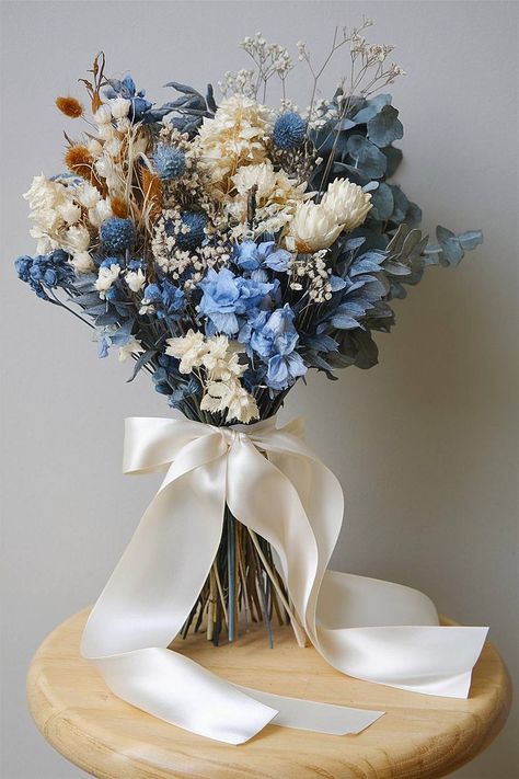 A blue and white bridal bouquet with dried and fresh flowers. Wildflower Bouquet Blue, Bride Bouquets Blue, Baby Blue Bouquet, Blue And White Bridal Bouquet, Blue And White Bouquet, Blue Hydrangea Bouquet, Blue Flower Arrangements, Unique Bouquets, Elegant Wedding Bouquets