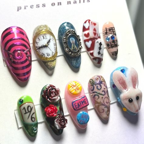 Alice in Wonderland 🌀🐇✨🍄 Tier 3 This set if one of my most time consuming and difficult set I’ve made so far however it’s one my favourites and I love it just as much as I love the movie Follow @moneta_nails1 for more nails and DM flr custom sets #nail #nailsofinstagram #nailsnailsnails #nailsart #smallbusiness #smallbusinessowner #pressonnails #pressons #pressonnailsforsale #pressonnailset #aliceinwonderland #alice #whiterabbit #madhatter #johnnydepp #queenofhearts Alice In Wonderland Inspired Nails, Alice Nails Wonderland, Mad Hatter Nail Designs, Alice In Wonderland Nails Designs, Alice And Wonderland Nails, Cheshire Nails, Nail Art Alice In Wonderland, Alice Madness Returns Nail Art, Alice In Wonderland Nails Easy