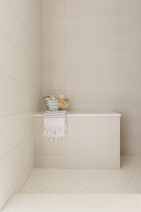 Ivory hexagon floor tiles frame a cream tiled shower bench fitted with a white quartz top fixed in a corner against large cream staggered surround tiles. Tiled Shower Bench, Large White Tiles, Hexagon Floor Tiles, Large Shower Tile, White Shower Tile, Restroom Remodel, Hexagon Floor, White Bathroom Tiles, Shower Cream