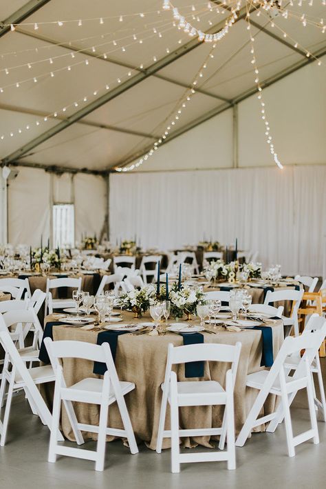 Tented reception with white folding chairs Wedding Table White Chairs, White Chair Wedding Reception, Wedding Reception White Chairs, White Folding Chairs Wedding Reception, White Resin Chairs Wedding, Reception Set Up, Wedding With White Chairs, Folding Chair Decorations Wedding, Resin Chairs Wedding