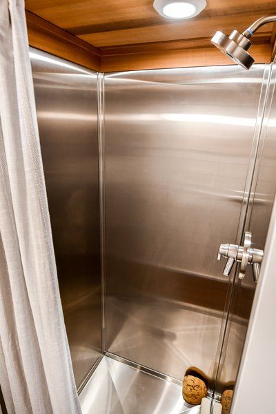 Bath Room, Metal Wall, Full Shower, and Open Shower Stainless steel shower.  This Custom Tiny Home Has a Clever, Space-Saving Elevator Bed by Tru Form Tiny Elevator Bed, Camping Bathroom, Bathtub Shower Combo, Doorless Shower, Tiny House Village, Open Showers, Bathtub Tile, Tiny Bathrooms, Stainless Steel Bathroom