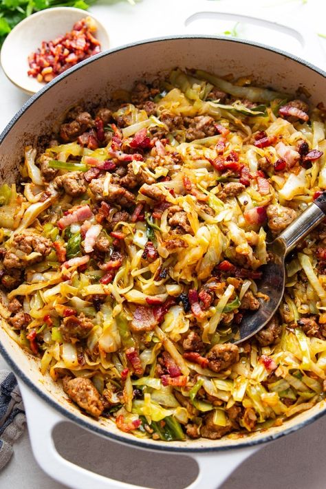 This recipe for Fried Cabbage With Sausage is so simple yet so delicious. Tender chunks of Italian sausage sauteed with onions and fresh cabbage topped with salty bacon bits make this one-pot meal ideal for a busy weeknight. Cabbage With Sausage, Fried Cabbage With Sausage, Low Carb Vegetable Soup, Fried Cabbage Recipes, Kielbasa And Cabbage, Bacon Fried Cabbage, Oxtail Recipes, Cabbage And Sausage, Mushroom Cream Sauces