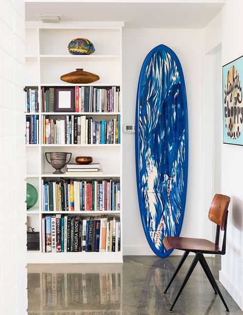 Surfer vignettes In a nod to his passion for surfing, Randy has a wood board shaped by famed surfer Greg Noll. It’s based off a board shape common in Hawaii that was used more than 100 years ago. Furthermore, “I have every issue of every surf magazine published until about 2000,” Randy says. He references them—and his large collection of surfer and beach culture books—for inspiration for his line of surfer clothing, M. Nii. Ideas For Shelves, Surf Shack Decor, Mid Century Modern Makeover, Book Shelf Styling, Surfboard Storage, Mudroom Bathroom, Bookshelves Decor, Home Decor Colorful, Mavericks Surfing