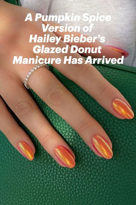 Orange almond-shaped nails holding a green purse Glazed Pumpkin Nails, Orange Glazed Donut Nails, Burnt Orange Glazed Nails, Hailey Bieber Orange Nails, Glazed Donut Nails Orange, Orange Hailey Bieber Nails, Glazed Orange Nails, Orange Irridescent Nails, Iridescent Orange Nails