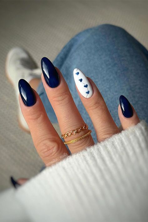 Dark navy blue almond-shaped nails with an accent white nail adorned with navy blue heart shapes Blue Autumn Nails, Biab Nails, Hoco Nails, Dark Blue Nails, Navy Nails, Simple Fall Nails, November Nails, Simple Gel Nails, Girly Acrylic Nails