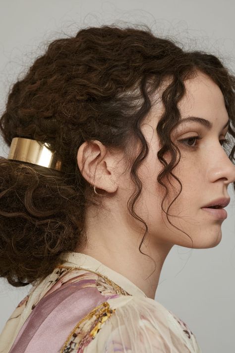 For a minimalist yet chic look, gather your long curls into a messy low bun and secure it with a gold hair cuff. The gold cuff adds a sleek, modern edge to your casual hairstyle, giving it a sophisticated twist. Hair With Accessories, Messy Low Bun, Long Layered Hairstyles, Long Layered Curly Hair, Half Up Curls, Curly Layers, Hair Cuff, Messy Curly Bun, Layered Curls