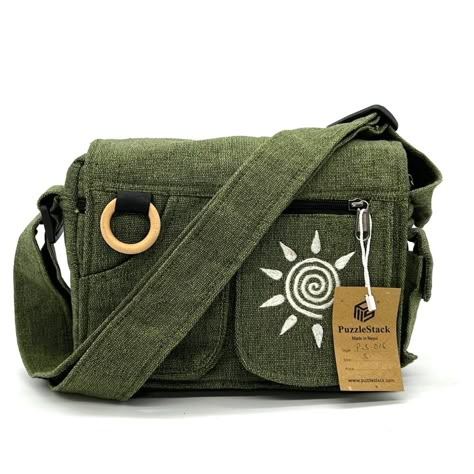 Puzzlestack’s Lukla Green Embroidered Messenger Bag Is A Compact Yet Voluminous Bag. Along With Its Multiple Pockets Used For Storage, It Includes A Large Flap Closure With Velcro. Starting Off With The Two Front Pockets, Open Up The Flap To Find The Main Compartment Following The Large Extra Pocket, And Even A Cute Mini Side Pocket! Make Travel Hands-Free With This Spacious Bag. Express Yourself With 5 Different Hand Embroidered With Thread Designs To Choose From! Not Only Is This Bag Sustainab Green Messenger Bag, Sun Embroidery, Green Backpack, College Gifts, Side Bags, Eco Bag, Embroidered Design, Green Bag, Side Pocket